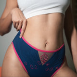 Person wearing a white crop top and blue underwear with pink accents.