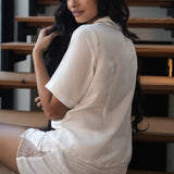 Woman in a white outfit sitting on wooden stairs