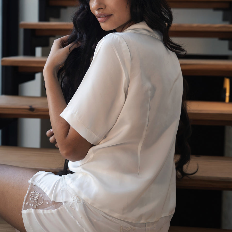 Woman in a white outfit sitting on wooden stairs